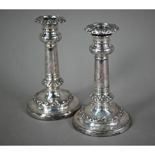 183 - A pair of George IV loaded silver candlesticks with foliate-chased decoration, on circular bases, Wi... 