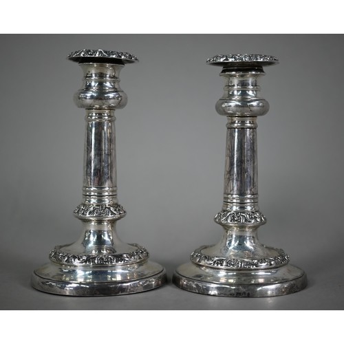 183 - A pair of George IV loaded silver candlesticks with foliate-chased decoration, on circular bases, Wi... 