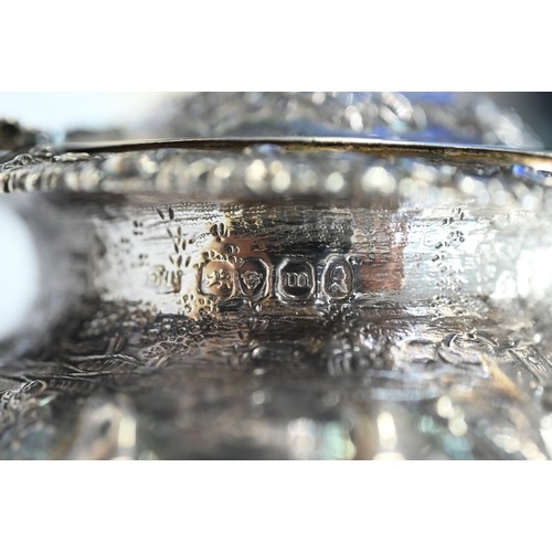 176 - A good George IV silver mustard with hinged cover, scroll handle and stemmed foot, richly embossed a... 