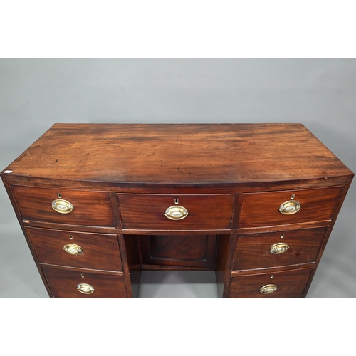 410 - # A Victorian mahogany bowfront kneehole desk, with six drawers and recessed cupboard, raised on spl... 