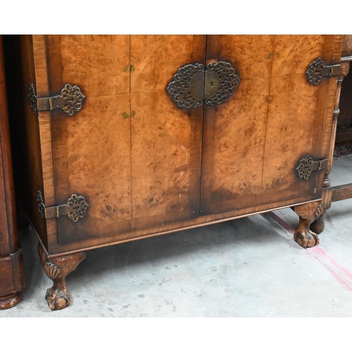 411 - An Oriental style walnut two door cocktail/side cabinet with engraved brass mounts, shell carved bal... 