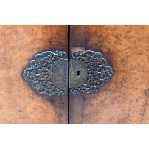 411 - An Oriental style walnut two door cocktail/side cabinet with engraved brass mounts, shell carved bal... 