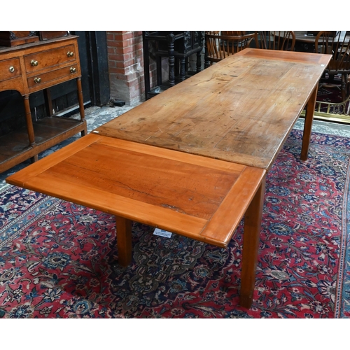 541 - An antique French cherry wood farmhouse table, the plank top with cleated ends and later draw leaf e... 