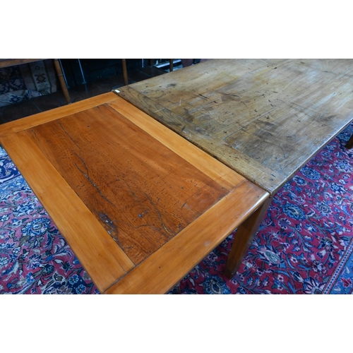 541 - An antique French cherry wood farmhouse table, the plank top with cleated ends and later draw leaf e... 