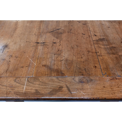 541 - An antique French cherry wood farmhouse table, the plank top with cleated ends and later draw leaf e... 