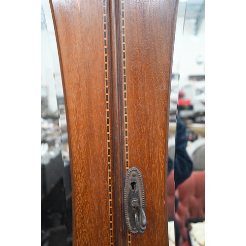 487 - # An Edwardian walnut inlaid wardrobe, the two doors inset with bevelled oval mirrors enclosing hang... 