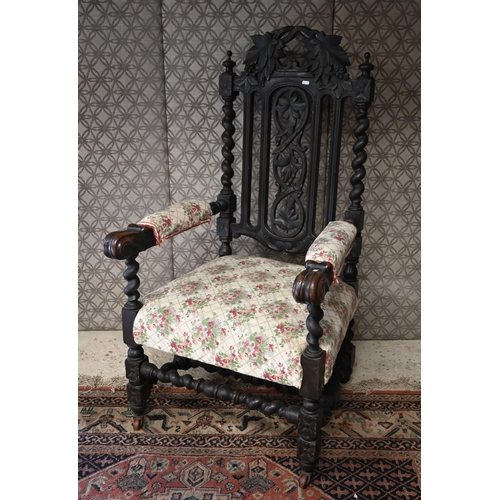 554 - An antique Gothic Revival carved oak open armchair, floral upholstery