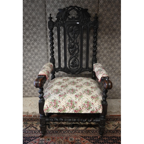 554 - An antique Gothic Revival carved oak open armchair, floral upholstery