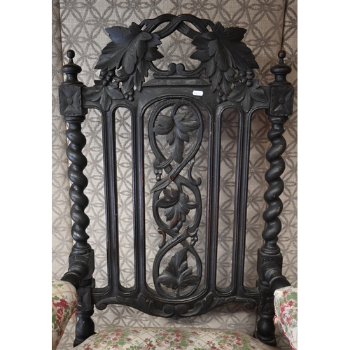 554 - An antique Gothic Revival carved oak open armchair, floral upholstery