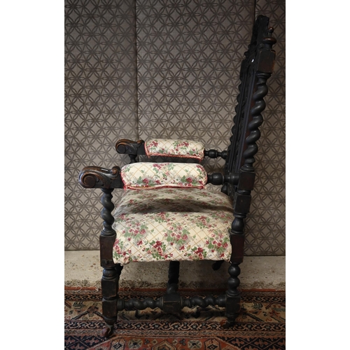 554 - An antique Gothic Revival carved oak open armchair, floral upholstery