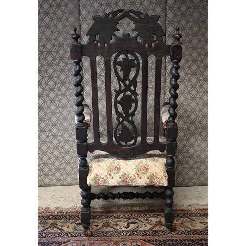 554 - An antique Gothic Revival carved oak open armchair, floral upholstery