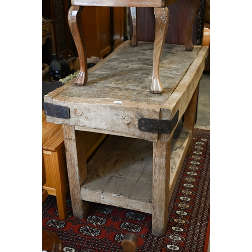 333 - An old beech end grain butcher's block on pine base, the worked rectangular top with iron corner bra... 