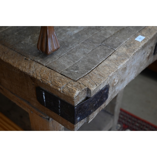 333 - An old beech end grain butcher's block on pine base, the worked rectangular top with iron corner bra... 