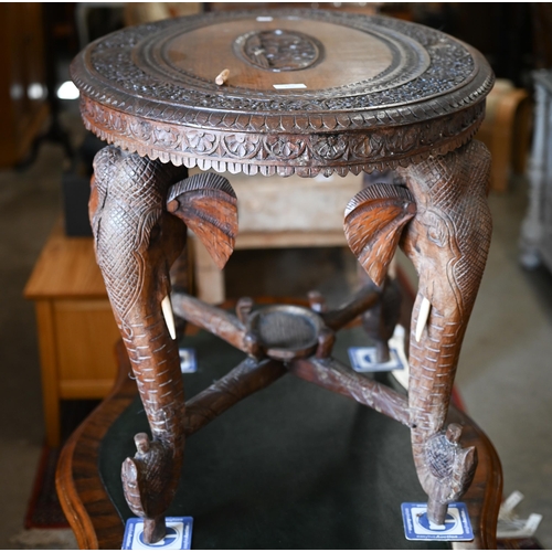 356 - An Anglo-Indian hardwood 'elephant' table, the oval top profusely carved with swaths of repeating fo... 