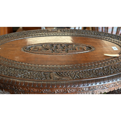 356 - An Anglo-Indian hardwood 'elephant' table, the oval top profusely carved with swaths of repeating fo... 