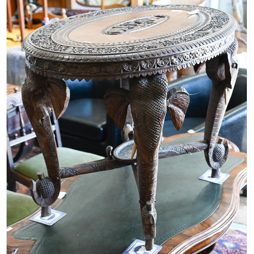 356 - An Anglo-Indian hardwood 'elephant' table, the oval top profusely carved with swaths of repeating fo... 