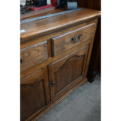 368 - A good quality modern oak sideboard with three drawers over panelled cupboards standing on bracket f... 