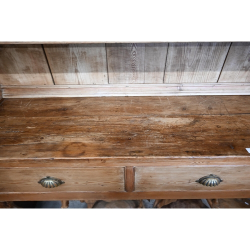 373 - A large antique pine dresser with plate rack over three drawer base with cupped handles and shaped s... 