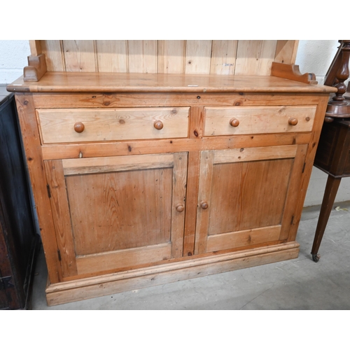 381 - A vintage waxed pine dresser, the raised back with leaded and stained glass doors on base with two d... 