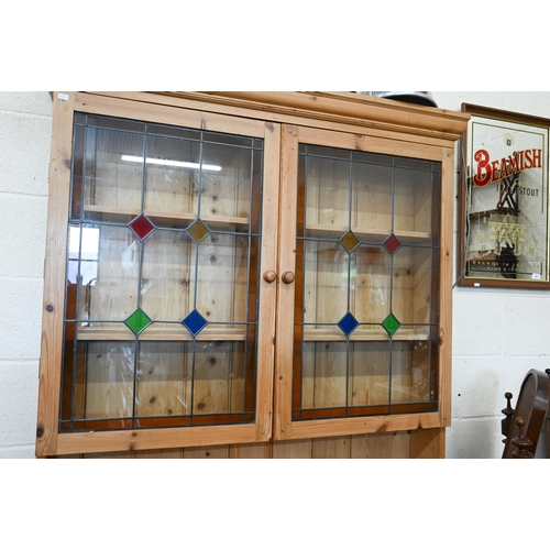 381 - A vintage waxed pine dresser, the raised back with leaded and stained glass doors on base with two d... 