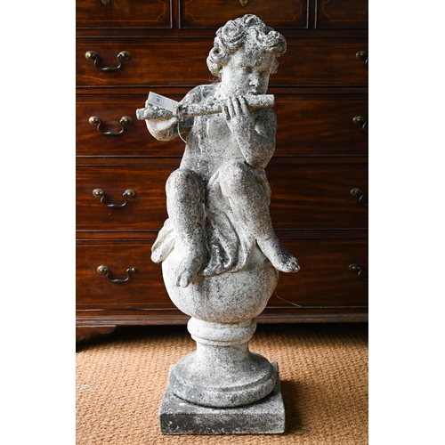 51A - A weathered cast stone cherub playing a flute, seated on a ball, 100 cm h