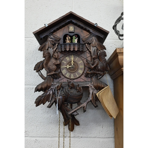 584 - A German Schneider carved wood cuckoo clock with revolving dancing couples below the cuckoo, above s... 