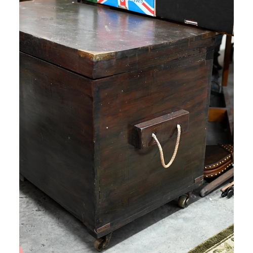 604 - An antique brass bound teak trunk with rope carrying handles, on castors 102 x 54 x 70 cm high