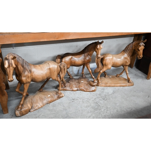 629 - A trio of carved hardwood stallion sculptures (3)