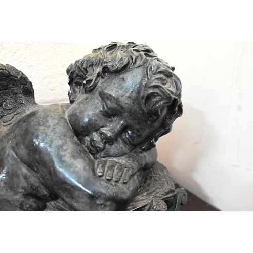 639 - A verdigris-patinated pottery recumbent putto in the Regency style