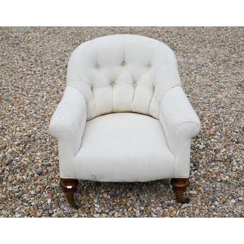 319 - An Edwardian calico button upholstered chair on turned mahogany front legs to brass castors