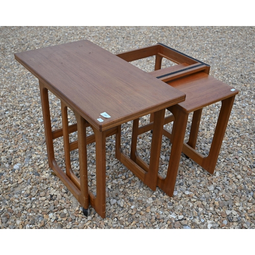 558 - A mid century teak folding tea table with two nesting tables below by McKintosh