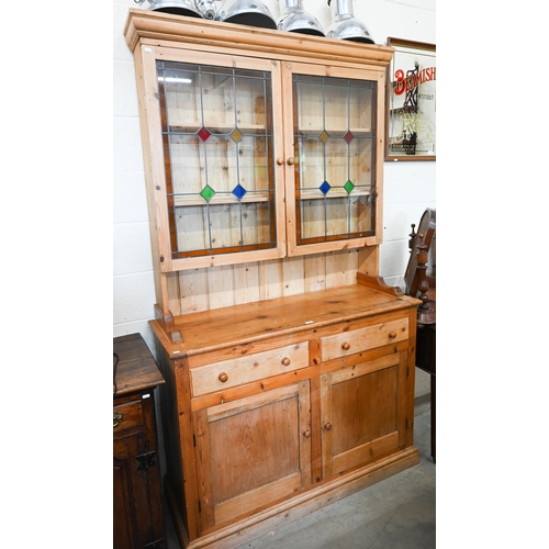 323 - A vintage waxed pine dresser, the raised back with leaded and stained glass doors on base with two d... 