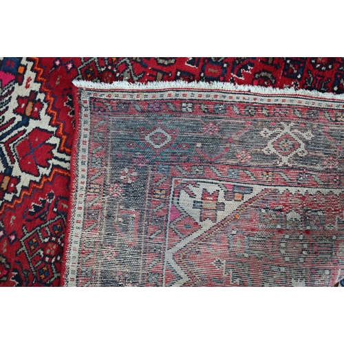 365 - An old Persian Hamadan kelleh carpet, the red ground with geometric garden design, 270 cm x 150 cm