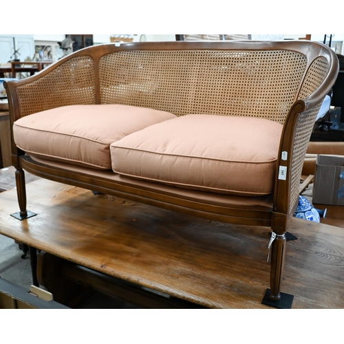 247 - A walnut framed double caned two seater bergere sofa on fluted supports, 130 cm wide x 60 cm deep x ... 