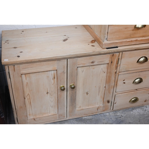 371 - A stripped pine side cabinet with panelled doors and three drawers with brass handles, 122 x 30 x 60... 