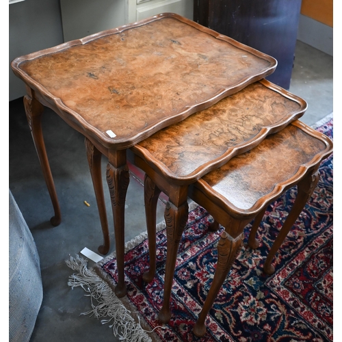 399 - A nest of three reproduction walnut veneered tables and a low carved chair (4)