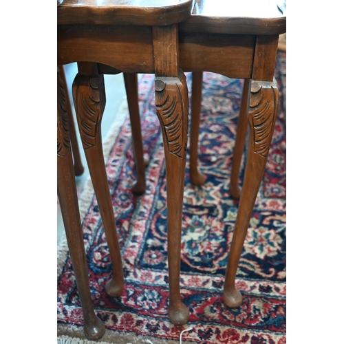 399 - A nest of three reproduction walnut veneered tables and a low carved chair (4)