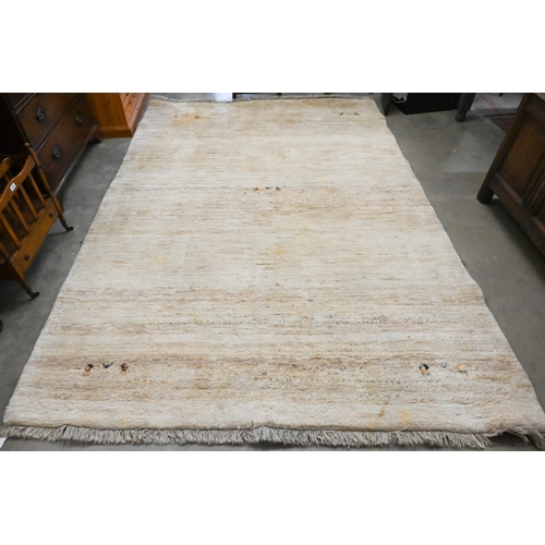 421 - A thick pile Gabbeh wool rug with small animal corner motifs on beige ground, 290 cm x 195 cm