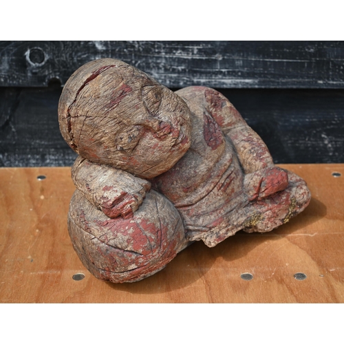 431 - An antique heavily weathered Asiatic carved hardwood reclining buddha, light remnants of polychrome ... 