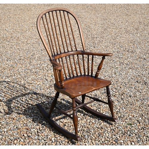 483 - A traditional stained ash and elm stick-back rocking elbow chair