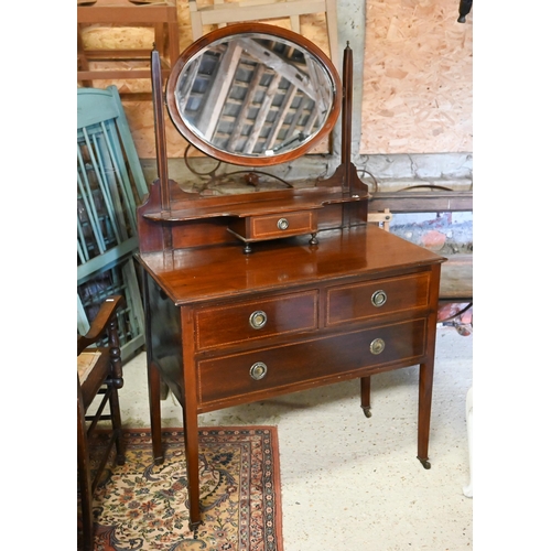 499 - An Edwardian inlaid satinwood oval mirror backed three drawer dressing chest, raised on square legs ... 