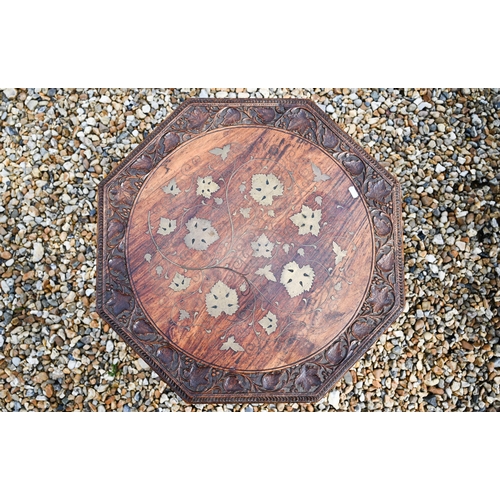 502 - An antique carved and brass inlaid Indian low table on tripod base, 61 x 59 x 43 cm h to/w another w... 