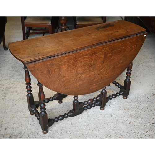 504 - An antique oak circular gateleg supper table, raised on a turned frame, 122 x 122 x 75 cm h