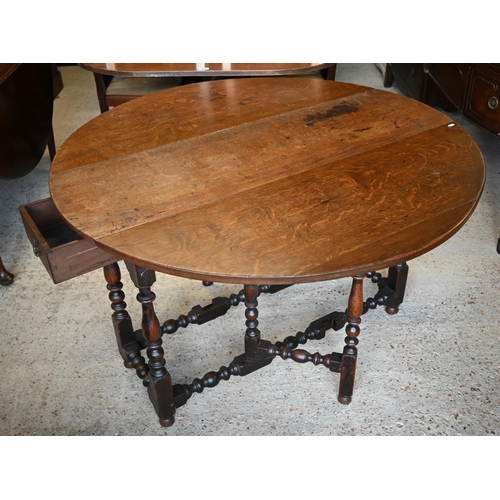 504 - An antique oak circular gateleg supper table, raised on a turned frame, 122 x 122 x 75 cm h