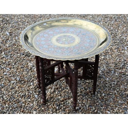 511 - A large chased and engraved brass, white metal and copper circular tray on a carved folding stand, 7... 