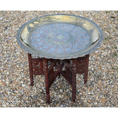 511 - A large chased and engraved brass, white metal and copper circular tray on a carved folding stand, 7... 