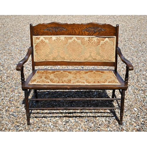 514 - An old oak part-upholstered two seat sofa bench, 105 cm w