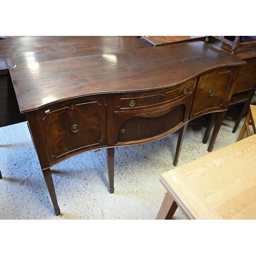 94 - A mahogany serpentine front sideboard, centred by a frieze drawer over a tambour cupboard flanked by... 