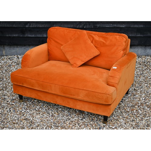 157 - A contemporary plush burnt orange upholstered 'love chair', raised on turned front legs to brass cas... 