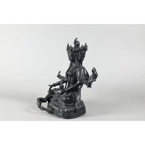 443 - A Nepalese bronze figure of the three-faced Buddhist goddess Vasudhara, seated in royal ease positio... 